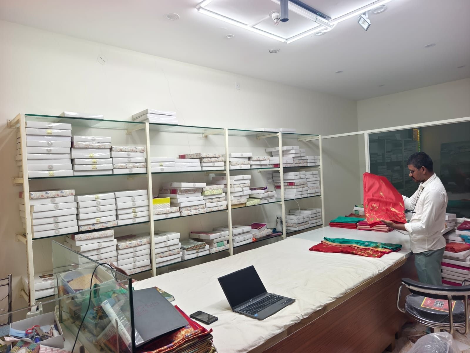 Ramanji Handlooms staff presenting a silk saree at the showroom counter