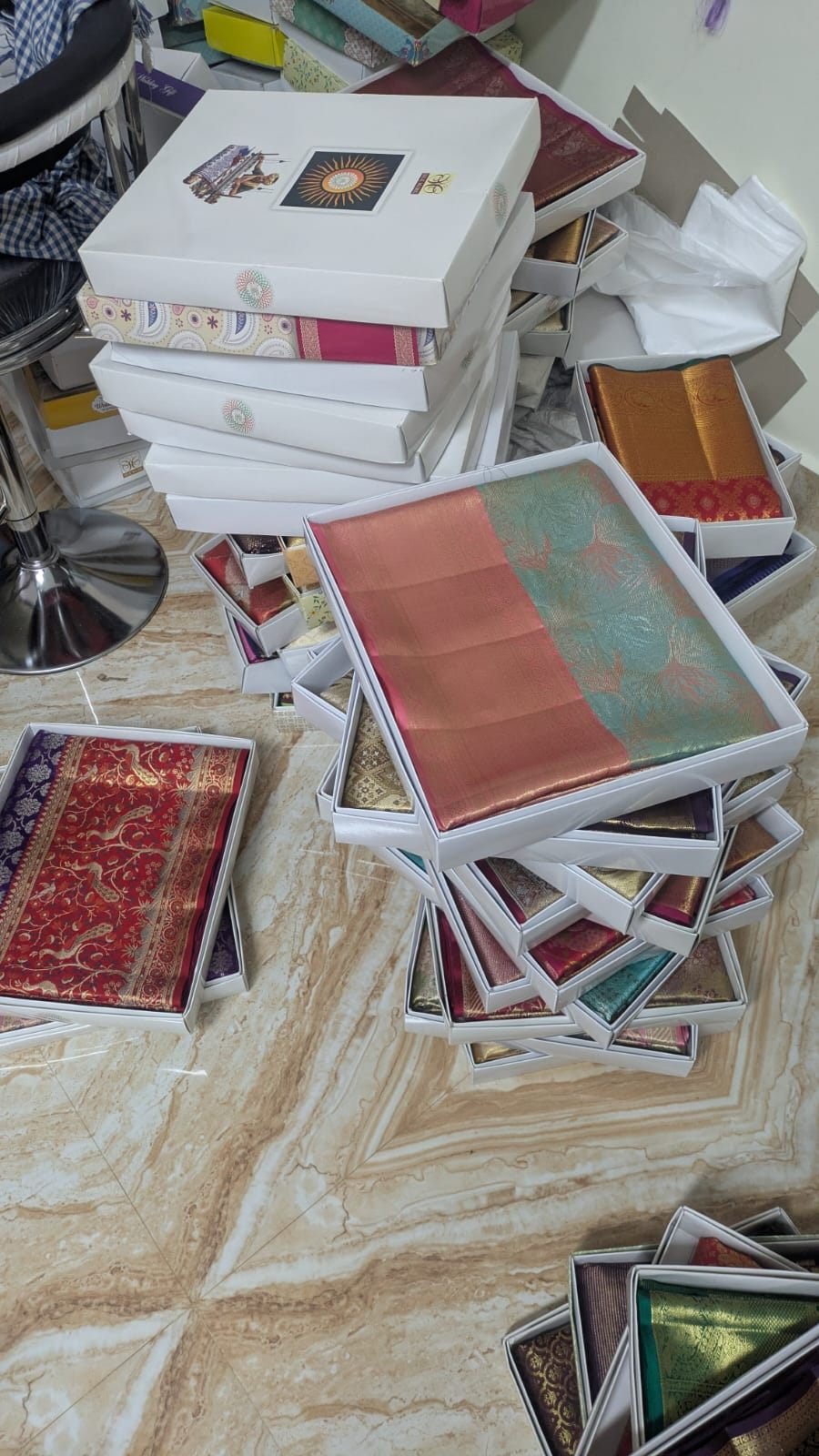 Wide collection of handloom silk sarees in boxes on the Ramanji Handlooms showroom floor, Dharmavaram